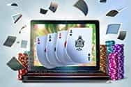 A laptop bursting with playing cards.