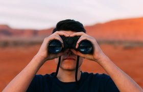 Nærbillede af en mand med en kikkert.