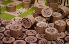 Træbrikker med numre og en bingoplade i baggrunden