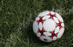 En fodbold på grøn græsplæne.