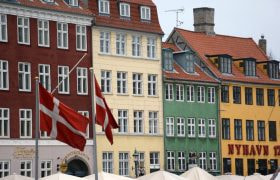 Dannebrog foran farverige bygninger i Nyhavn