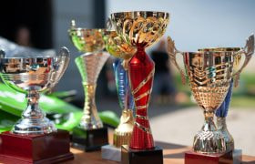 Fem trofæer placeret på bord.