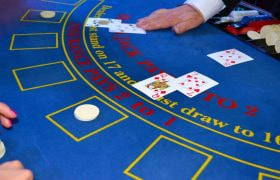 Kortuddeling på blåt blackjack bord.