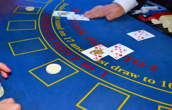 Kortuddeling på blåt blackjack bord.