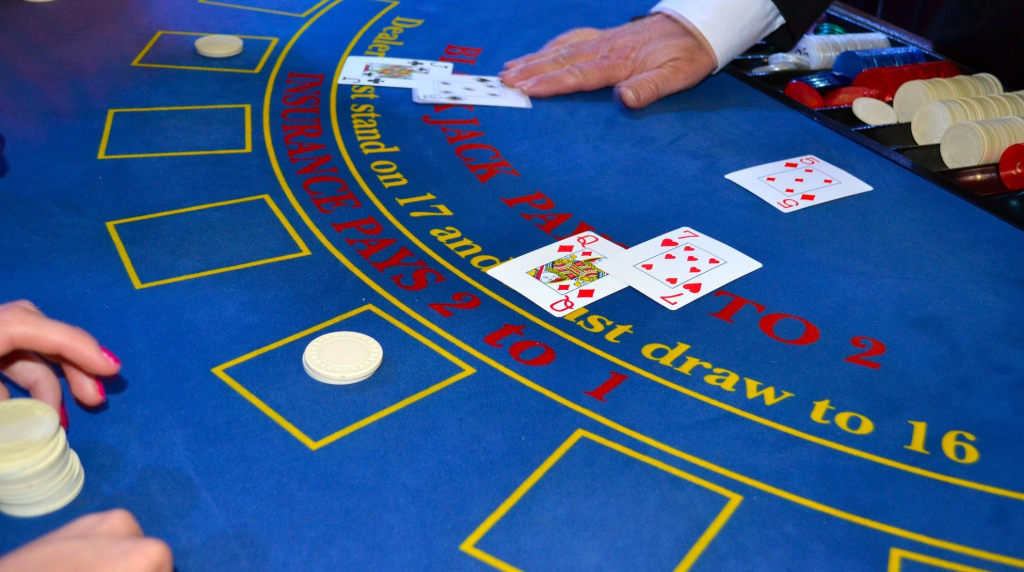 Kortuddeling på blåt blackjack bord.