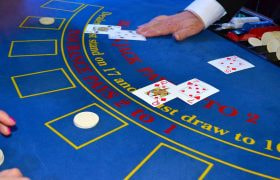 Kortuddeling ved blåt blackjack bord.