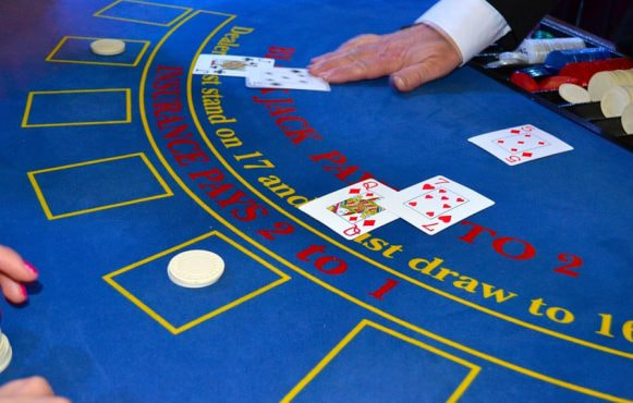 Kortuddeling ved blåt blackjack bord.