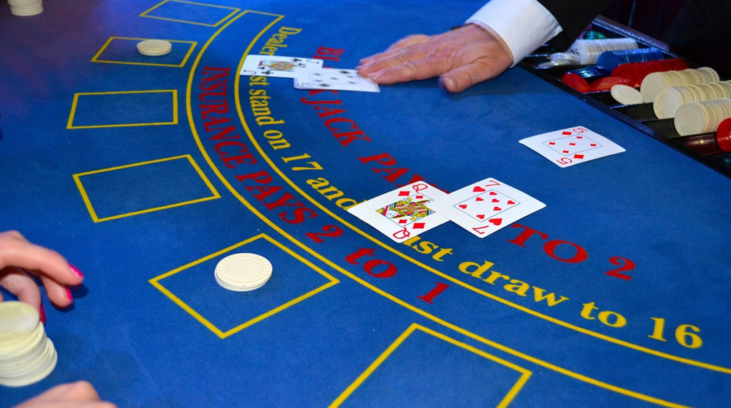 Kortuddeling ved blåt blackjack bord.