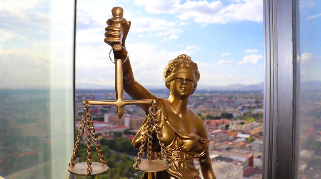 Retfærdighedsstatue foran by Horisont