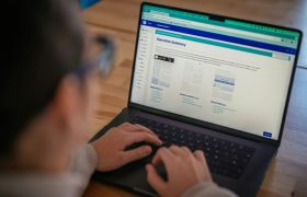 Mand skrive på bærbar på bord.