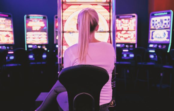 Kvinde sidder afslappet og spiller på slots.