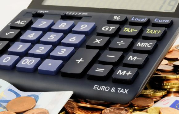 Una calcolatrice con monete e banconote in euro