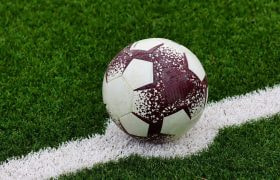 Pallone da calcio consumato, fermo sulla linea bianca