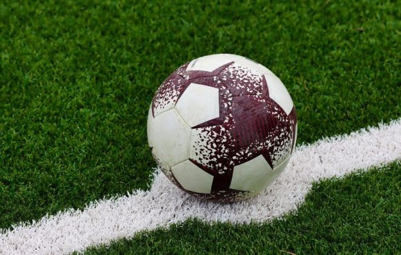 Pallone da calcio consumato, fermo sulla linea bianca