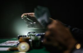 Giocatore al tavolo da poker con fiches e carte