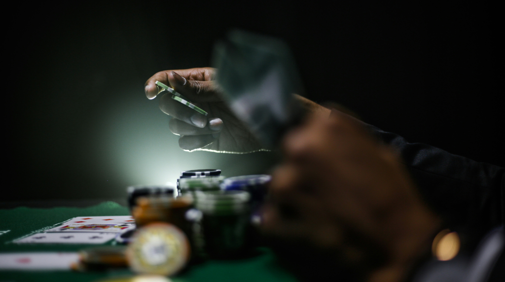 Giocatore al tavolo da poker con fiches e carte