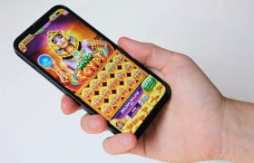 Mano tiene smartphone con slot machine ispirata all’antico Egitto
