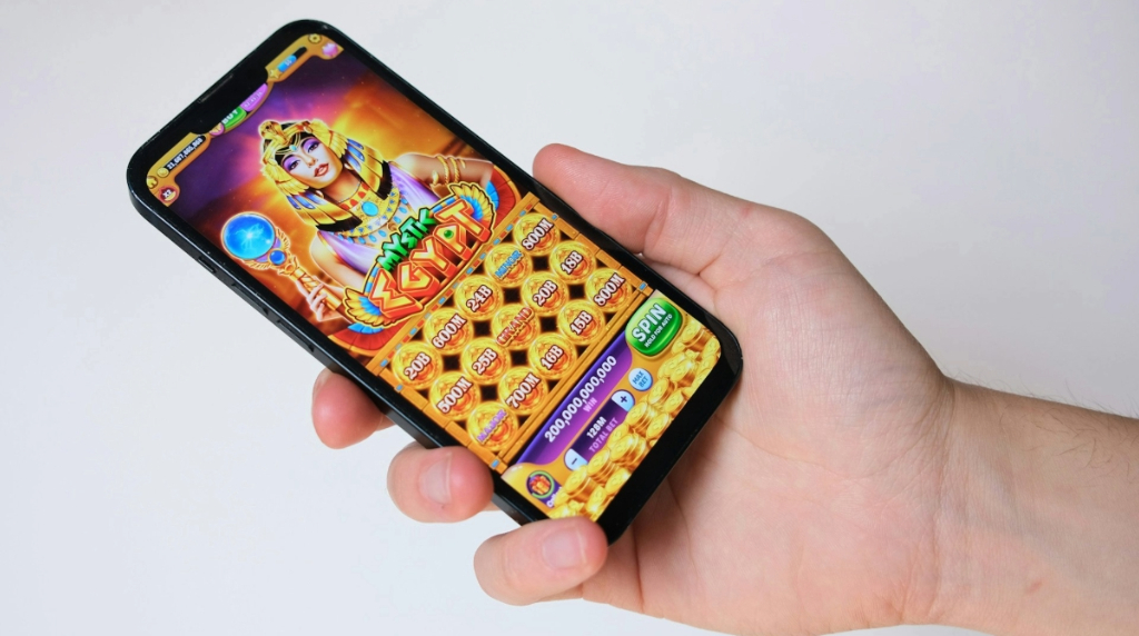 Mano tiene smartphone con slot machine ispirata all’antico Egitto