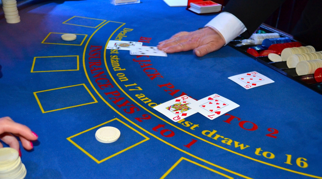 Tavolo da blackjack con carte, fiches e mazziere in azione