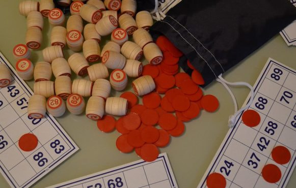 Cartelle bingo, gettoni rossi e numeri legno