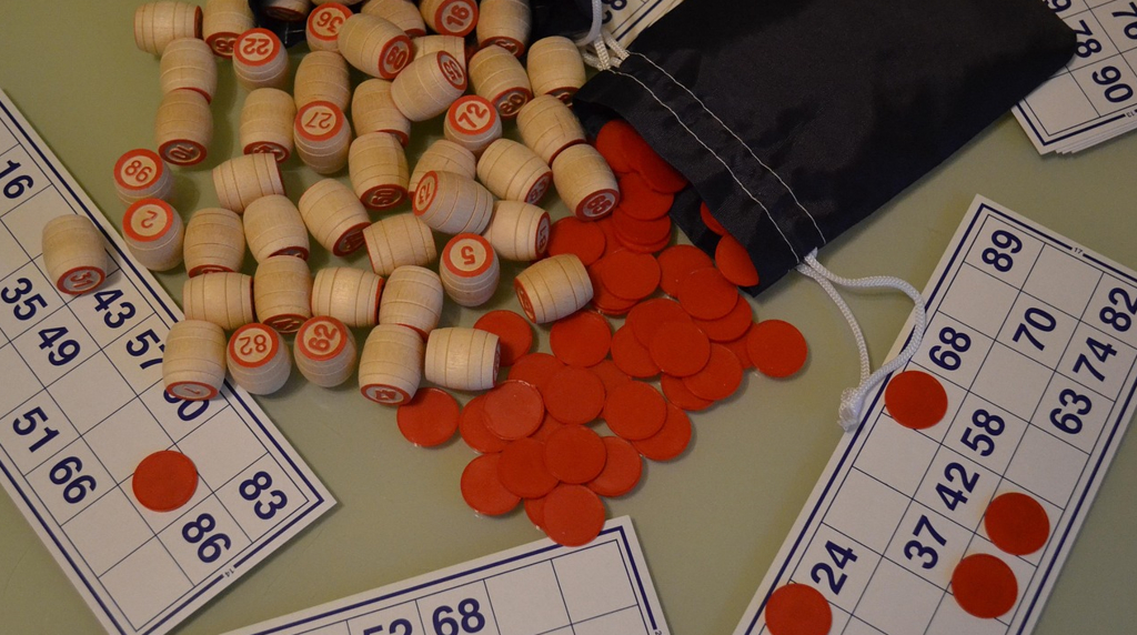 Cartelle bingo, gettoni rossi e numeri legno
