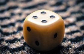 Dado giallo a sei facce su sfondo testurizzato
