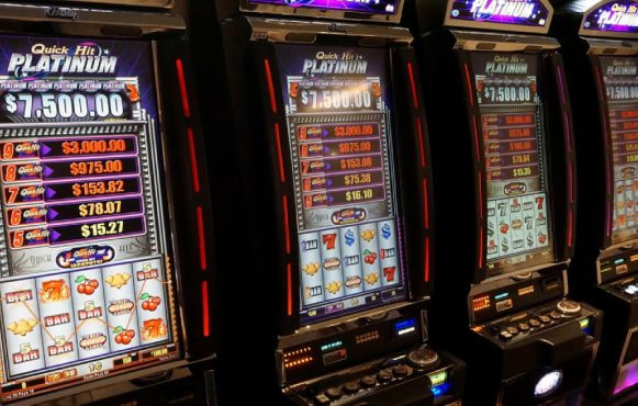Quattro slot machine accese con rulli e jackpot