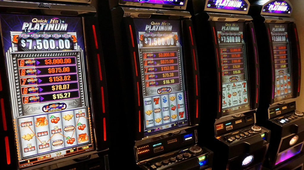 Quattro slot machine accese con rulli e jackpot