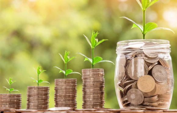 Monete impilate con piantine crescenti