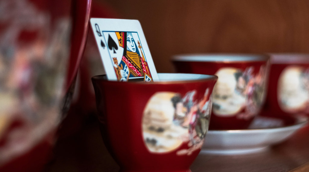 Carta da gioco in tazza rossa decorata su scaffale