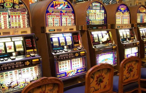 Slot machine colorate in fila dentro un casinò.