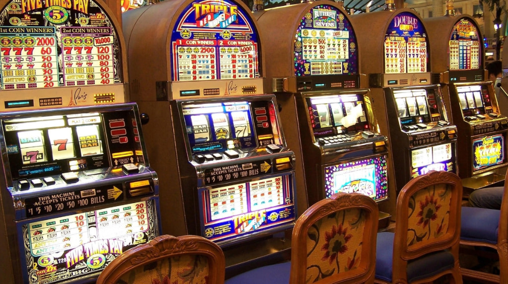 Slot machine colorate in fila dentro un casinò.