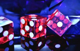 Dadi rossi traslucidi su sfondo blu riflettente.