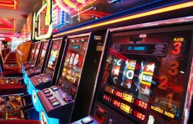 Sala slot luminosa con file di macchine e rulli in movimento