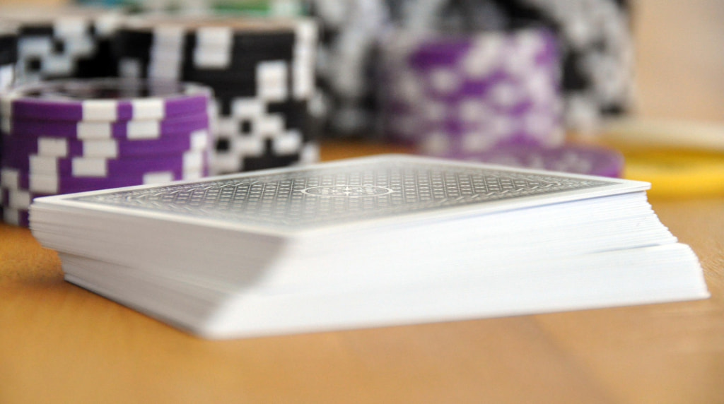 Mazzo di carte con fiches da casinò sfocate