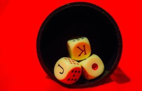 Dadi da gioco illuminati su sfondo rosso intenso