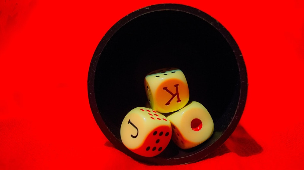 Dadi da gioco illuminati su sfondo rosso intenso