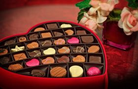 Scatola a cuore con cioccolatini assortiti e fiori