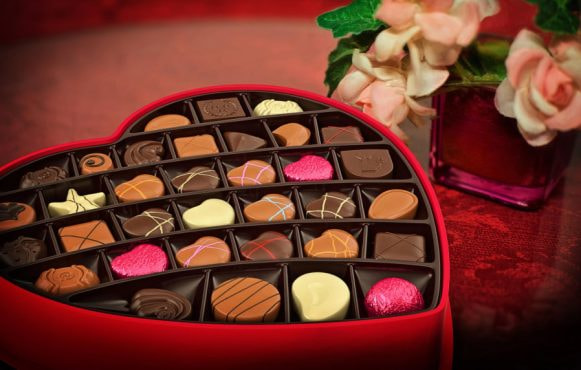 Scatola a cuore con cioccolatini assortiti e fiori