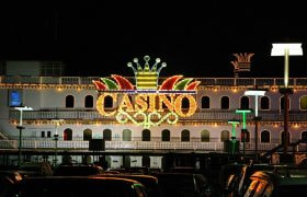 Insegna luminosa casinò notturno con parcheggio urbano illuminato