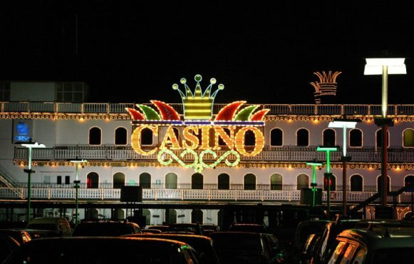 Insegna luminosa casinò notturno con parcheggio urbano illuminato