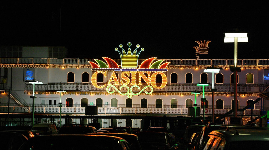 Insegna luminosa casinò notturno con parcheggio urbano illuminato