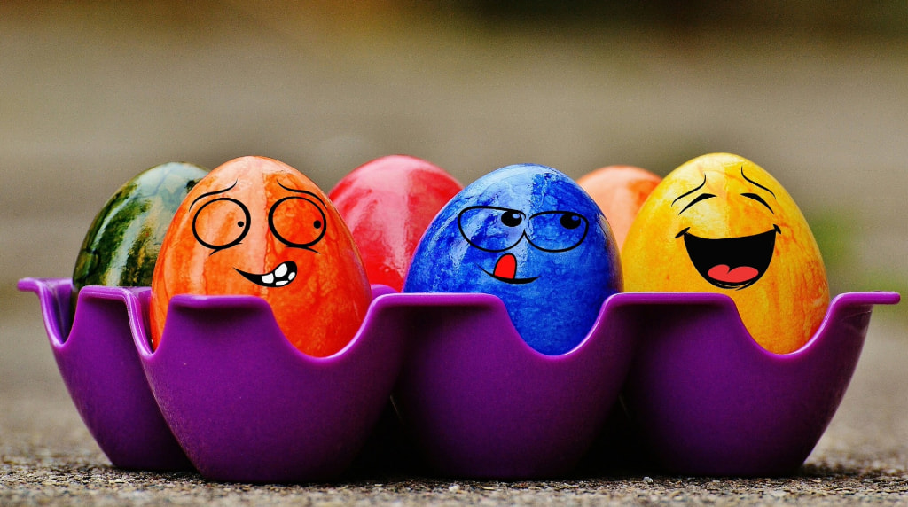 Uova di Pasqua colorate con facce sorridenti in portauova viola.