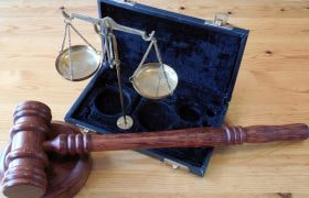 Bilancia e martelletto giudiziario su tavolo in legno