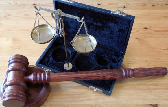 Bilancia e martelletto giudiziario su tavolo in legno