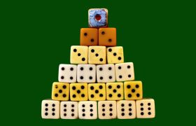 Piramide di dadi impilati su sfondo verde uniforme