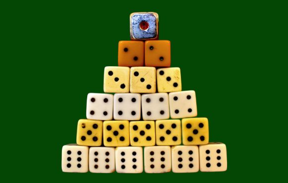 Piramide di dadi impilati su sfondo verde uniforme