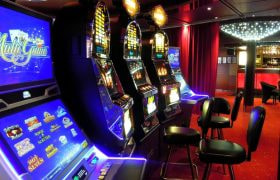Sala casinò con slot machine illuminate e sedute in fila