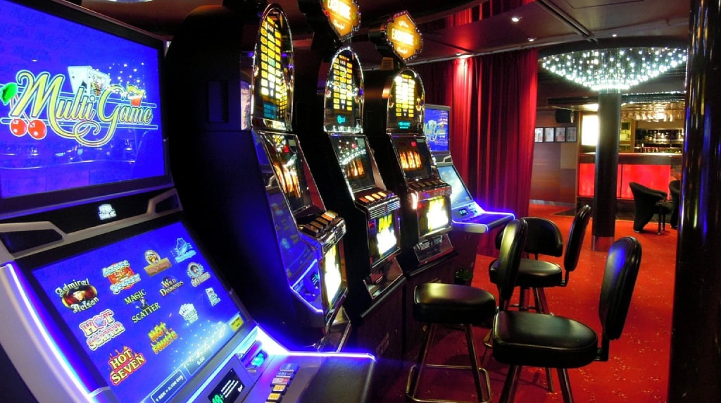 Sala casinò con slot machine illuminate e sedute in fila