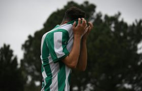 Voetballer baalt en trekt zijn groen/witte voetbalshirt over zijn hoofd.